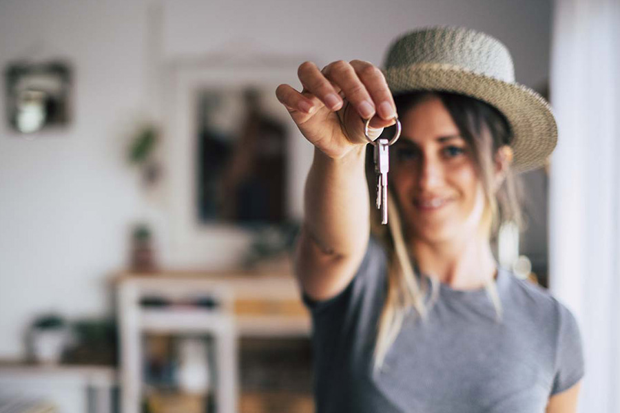 Renters Insurance - Close-up Blurred Image of a Happy Female Tenant Proudly Displaying House Keys in Focus as She Moves Into Her First Apartment